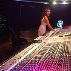 a woman standing in front of a sound board