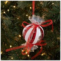 a red and white ornament hanging from a christmas tree