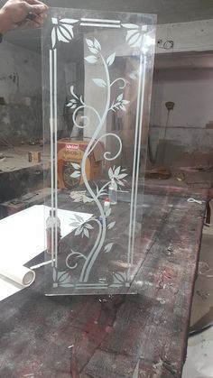 a clear glass box sitting on top of a piece of wood next to a table