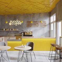 the interior of a coffee shop with yellow and grey accents on the walls, tables and chairs