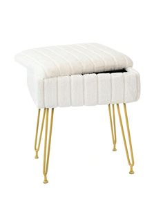 a white foot stool with gold legs