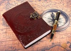 a notebook with a pen and compass on a map