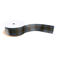 a roll of black watch tartan ribbon on a white background with a brown and blue plaid