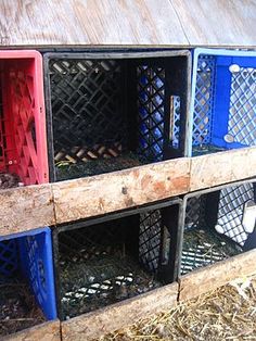 several different colored crates stacked on top of each other in the hay next to a building