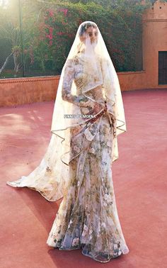 a woman in a wedding dress is standing on the red carpet with her veil over her head