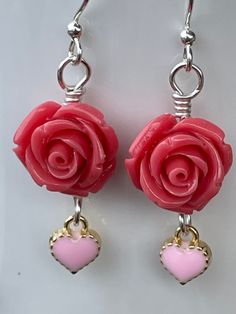 These serene Coral Rose Earrings are as soothing as the oceans waves. 14mm coral polyresin rose beads accented with a 8mm light pink heart charm. All hand wire wrapped in silver plated wire. 1.75 inches long. Let the coral reefs beckon to you. Pink Rose Design Flower Earrings For Valentine's Day, Pink Rose Design Earrings For Valentine's Day, Rose-colored Nickel-free Jewelry For Gifts, Pink Sterling Silver Flower Earrings For Gift, Pink Sterling Silver Flower Earrings As Gift, Rose Nickel Free Jewelry For Gift, Rose Nickel-free Jewelry For Gift, Dainty Pink Wire Wrapped Jewelry, Rose Earrings For Valentine's Day