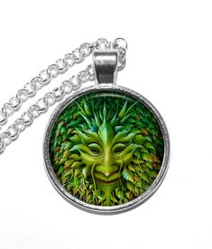 Handmade art pendant necklace featuring the Green Man. The Green Man is mainly associated with the symbol of rebirth, representing the cycle of growth each spring. Some say he is the ancient guardian of the forest. This beautiful art glass pendant has been carefully handcrafted by me in my home studio in Vaxholm, Sweden. The art print is covered with a clear glass domed cabochon which enhances the image, then set in a high quality metal setting. The pendant measures 36x28mm including bail. Each Symbolic Green Round Pendant Jewelry, Green Symbolic Nickel-free Jewelry, Green Symbolic Pendant Necklace, Artistic Green Round Pendant Necklace, Green Tree Of Life Jewelry Gift, Handmade Symbolic Green Necklace, Artistic Green Necklace For Gift, Tree Of Life Round Pendant Necklace, Spiritual Round Necklace With Artistic Design