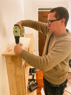 a man is sanding the wall with a power drill