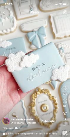 a hand is holding some cookies in front of other cookie cutters that have clouds on them