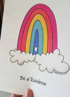 someone is holding up a drawing with a rainbow in the sky and clouds above it