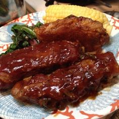 two pieces of meat on a plate with corn and broccoli