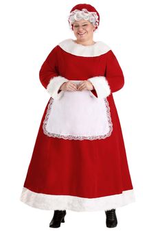 a woman dressed in a santa claus costume posing for the camera with her hands on her hips