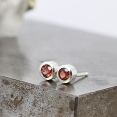 These small sterling silver stud earrings feature sparkly, deep red garnets set in a thick walled sterling bezel. These recycled gemstone studs are the perfect unisex gift and are ready to ship. Garnet is a birthstone for January.These are the perfect every day earrings with just a pop of gorgeous color. These would be perfect in a second piercing, or simply an understated everyday earring for a single piercing.Each gemstone measures 3mm in diameter. The total width of the earrings including the Silver Bezel Setting Earrings For Gift, Silver Bezel Set Earrings As Gift, Silver Garnet Birthstone Earrings, Sterling Silver Earrings With Bezel Setting As Gift, Silver Ruby Earrings With Birthstone, Single Piercing, January Birthstone Jewelry, Second Piercing, Unisex Gift