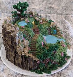 there is a cake that looks like a tree stump with plants on it and rocks in the middle