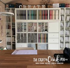 a room with bookshelves and shelves full of books on the wall, in front of a wooden table