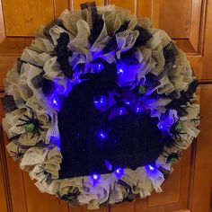 a wreath with blue lights on it is hanging on the front door to show off