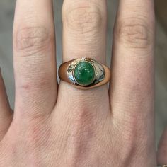 This Mid-Century cocktail ring features a cabochon cut natural green jade in 14k rose gold. The stone has a marvelous, tropical green hue set in glowing 14k rose gold. Reaching 5.48mm above the finger and weighing 4.9 grams, this Mid-Century statement cocktail ring is an outstanding piece of vintage jewelry! Composition: 14 Karat Rose Gold Ring Size: 10.5 Primary Stone: Green Jade Shape and Measurements: 9.41mm x 8.50mm General Characteristics: Height Above Finger: 5.48mm Measurements: 13.18mm T Green Oval Cabochon Emerald Ring, Fine Jewelry Emerald Green Oval Cabochon Ring, Green Emerald Ring With Oval Cabochon Bezel Setting, Green Cabochon Emerald Ring Fine Jewelry, Fine Jewelry Green Cabochon Emerald Ring, Fine Jewelry Green Emerald Cabochon Ring, Elegant Domed Emerald Ring, Green 14k Gold Signet Ring With Bezel Setting, Luxury Green Domed Ring