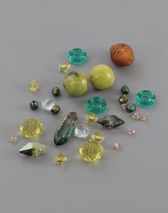 many different colored stones and beads on a gray surface