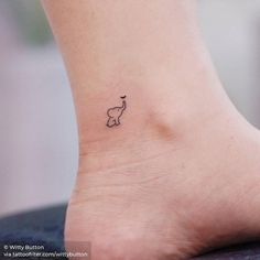 an elephant tattoo on the foot of a woman's left ankle is shown in black ink