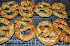 many pretzels are on a cooling rack and ready to be baked in the oven