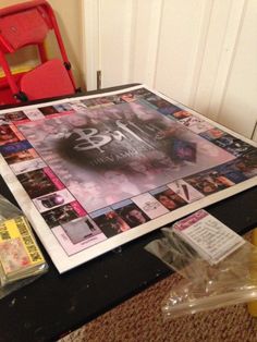 a table topped with magazines and plastic bags next to a red chair on top of a carpeted floor