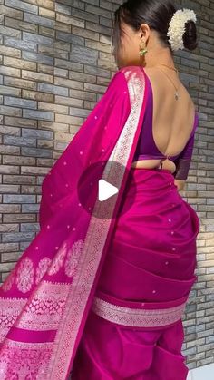 a woman in a pink sari with an intricately embroidered border on the back