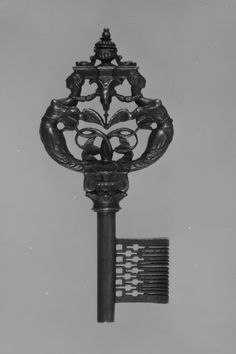 an old fashioned clock with ornate decorations on it's face and back side, attached to a metal pole