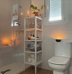 a white toilet sitting in a bathroom next to a bathtub filled with lots of candles