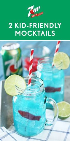 two mason jars filled with blue liquid and lime slices on a tray next to cans of soda