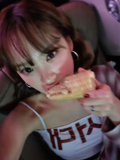 a young woman eating food in the back seat of a car