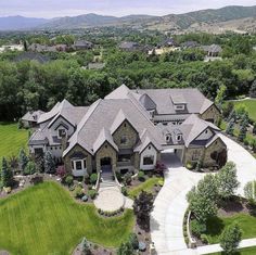 an aerial view of a large home in the middle of a lush green field with trees