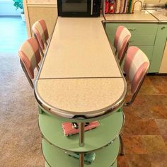 a kitchen with a microwave oven sitting on top of a counter next to a bunch of chairs