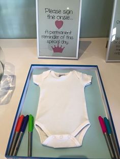 a baby's first birthday cake made to look like a bodysuit and crayons