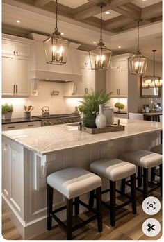 a kitchen island with four stools in front of it and lights hanging from the ceiling