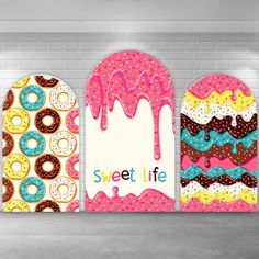 three donuts with different toppings on them are hanging from the wall in front of a brick wall