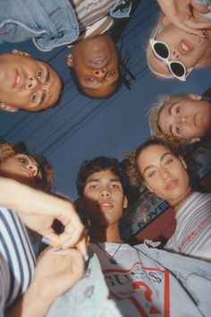 a group of people standing in a circle looking up at the camera with their eyes closed