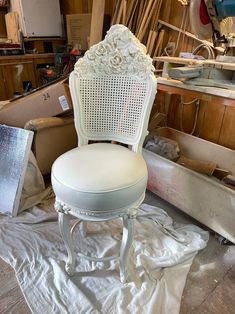 a white chair sitting on top of a pile of wood next to a wooden floor