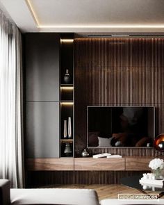 a modern living room with dark wood paneling and white couches in front of the tv