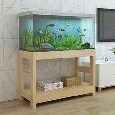 a fish tank sitting on top of a wooden shelf in front of a wall mounted tv