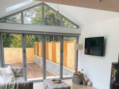 a living room filled with furniture and a flat screen tv mounted to the side of a wall