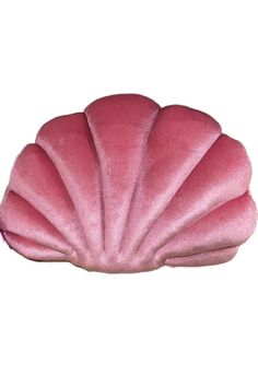 a pink scallop shaped pillow sitting on top of a white surface