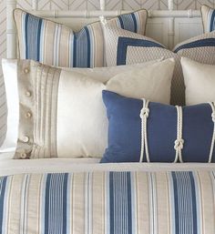 a bed with blue and white striped pillows