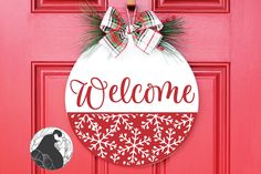 a red door with a welcome ornament hanging on it's front door