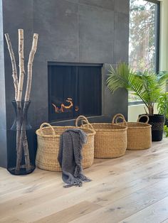 three wicker baskets sitting on the floor next to a fire place in a living room