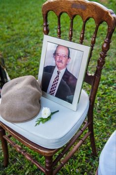 an old man's hat is sitting on a chair with a picture of him