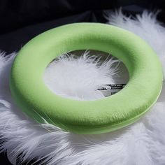 a green ring with white feathers around it