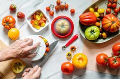 various types of tomatoes and other vegetables on a table