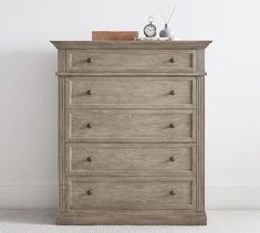 a wooden dresser sitting next to a white wall