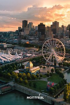 an aerial view of a city with a ferris wheel in the foreground and a river running through it