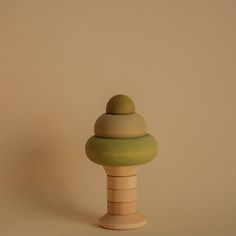 a wooden knob with a green top on a beige background